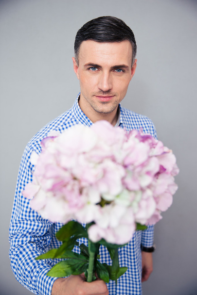 Happy man holding flowers - Foto, afbeelding