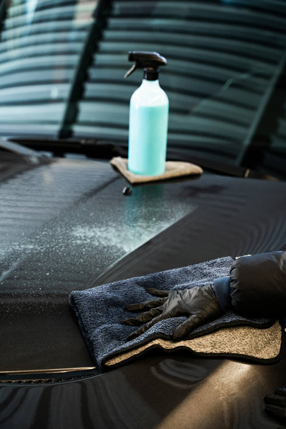 Applicazione di spray di rapido dettaglio sulla superficie dell'auto e lucidatura con stracci in microfibra. Processo di auto in dettaglio al servizio auto - Foto, immagini