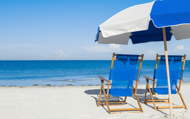 sun loungers and a beach umbrella on silver sand,  vacation conc - Photo, Image