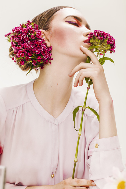 Mooi meisje portret dragen en houden van bloemen - Foto, afbeelding
