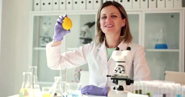 A mikroszkópos tudós citromot tart a laborban. A citrom előnyei és ártalmai, valamint a C-vitamin előnyös tulajdonságai - Felvétel, videó