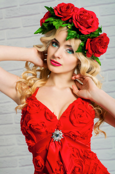 Beautiful girl with blond long hair in a red dress and a wreath - Fotografie, Obrázek