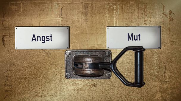 Een afbeelding met een wegwijzer die in twee verschillende richtingen wijst in het Duits. De ene richting wijst op moed, de andere op angst.. - Foto, afbeelding