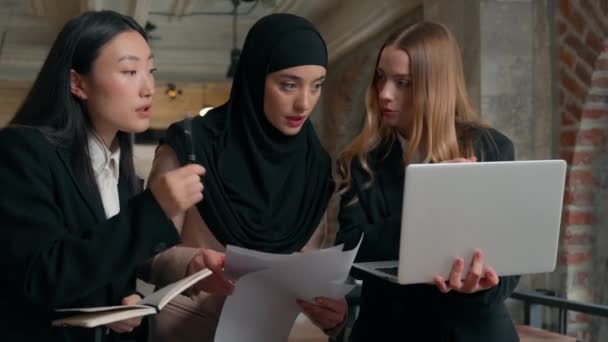 Felice riso multirazziale business colleghi di lavoro parlando sorridente risultato documenti femminili colleghi multietnici imprenditrici ragazze ufficio partenariato musulmano asiatico caucasico donne discutono progetto laptop - Filmati, video
