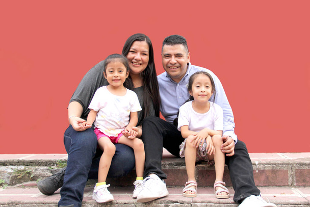 Семья папы, мамы и двух темнокожих латиноамериканских дочерей наслаждаются временем вместе смеяться и веселиться - Фото, изображение