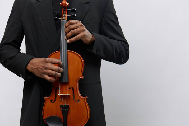 Professional African American musician in elegant suit holding violin against white background, classical music concept - Photo, Image