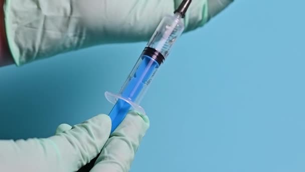 Spritze mit Impfstoff auf blauem Hintergrund - Filmmaterial, Video