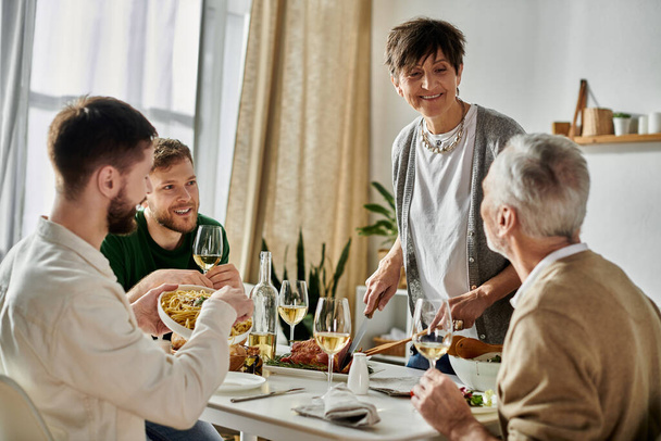 Um casal gay desfruta de uma refeição com os pais em casa. - Foto, Imagem
