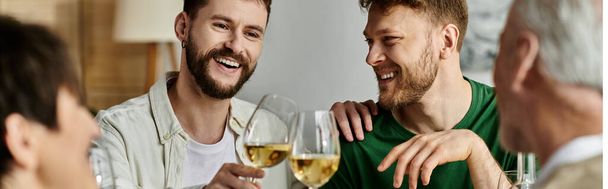 Una pareja gay disfruta de una copa con sus padres en casa. - Foto, imagen