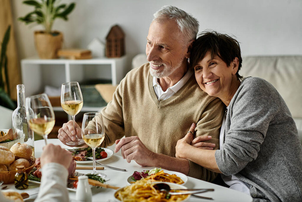 Los padres felices comparten la comida con su hijo y su pareja en una cena acogedora en casa. - Foto, imagen