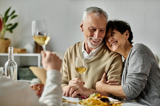 Os pais compartilham a refeição com seu filho e seu parceiro em um jantar acolhedor em casa. - Foto, Imagem