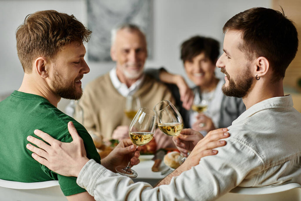 Um casal gay levanta um brinde com os pais em uma reunião em casa. - Foto, Imagem