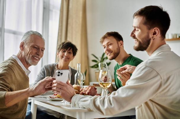 Um casal gay compartilha uma refeição com os pais em casa. - Foto, Imagem