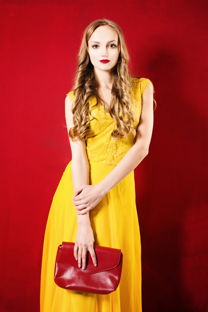 Kaunis nainen yllään keltainen mekko kirkkaan punainen tausta
 - Valokuva, kuva