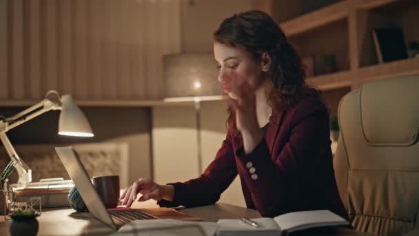 Fáradt nő néz dokumentumokat dolgozik laptop késő este közelről. Túlhajszolt üzletasszony, aki számítógépet gépel, és éjszaka vizsgálja a jelentést. Fáradt irodai dolgozó fogdossa halántékok érzés fejfájás. - Felvétel, videó