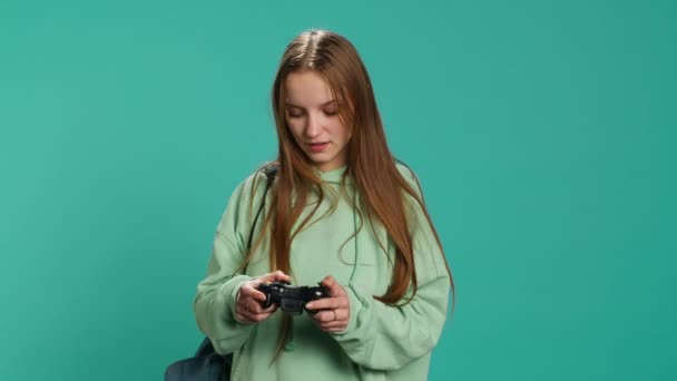 Euphoric woman playing intense gaming console game, celebrating win, studio background. Ecstatic young girl using controller, excited after being victorious in videogame, camera A - Séquence, vidéo