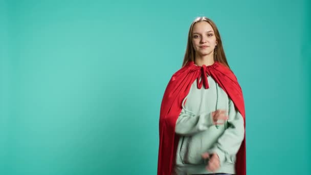 Ακτινοβόλος γυναίκα χαμογελά, ενώ απεικονίζει αυτοπεποίθηση superhero φορώντας κόκκινη κάπα, απομονώνονται σε στούντιο φόντο. Πορτρέτο του χαρούμενου ηρωικού προσώπου που παριστάνει τον ισχυρό ήρωα με κοστούμι, κάμερα B - Πλάνα, βίντεο