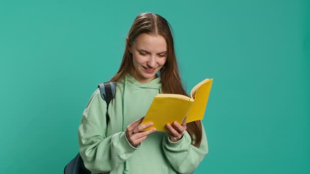 Молода дівчина читає книгу, насолоджується хобі, розважається, ізольована на фоні студії. Жінка з романом в обіймах розслабляється, розважається з цікавою історією, камера А - Кадри, відео