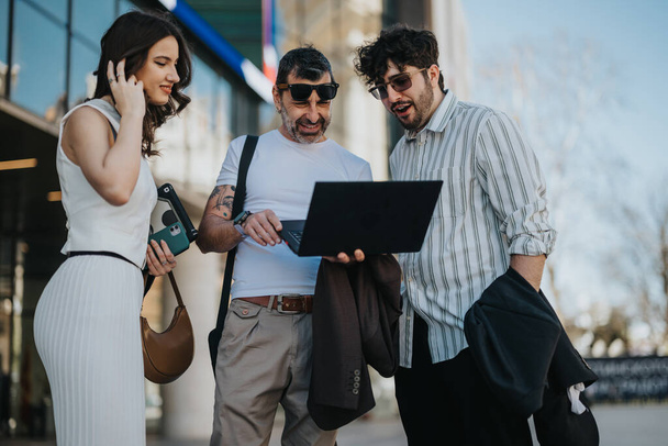 A multi-generational group of business professionals analyzes data on a laptop during an outdoor meeting, strategizing for improved success. - Photo, Image