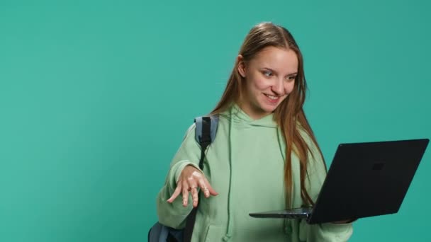Χαμογελαστή γυναίκα που έχει φιλική συνομιλία με τους φίλους κατά τη διάρκεια τηλεδιάσκεψης συνάντηση χρησιμοποιώντας φορητό υπολογιστή, στούντιο φόντο. Κορίτσι που διασκεδάζει συζητώντας με τους συντρόφους κατά τη διάρκεια σε απευθείας σύνδεση videocall, κάμερα A - Πλάνα, βίντεο