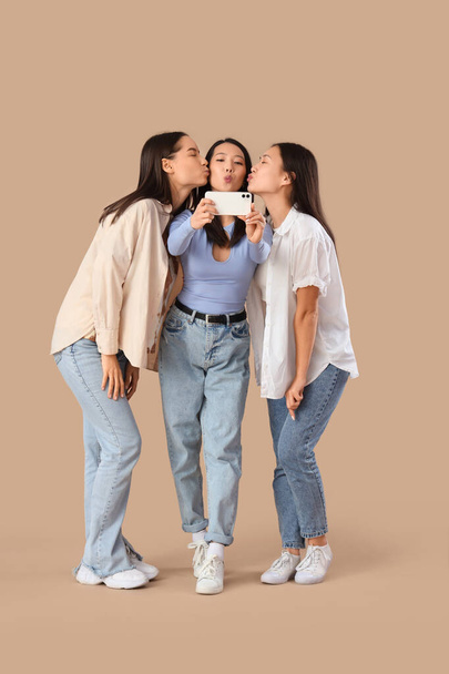 Giovani donne che scattano selfie su sfondo beige. Festa delle galline - Foto, immagini