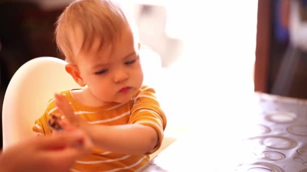 Küçük çocuk annesinden bir kaşık yulaf lapası alır ve kendini yer. Yüksek kalite 4k görüntü - Video, Çekim