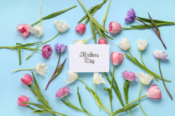 Grußkarte mit Text MUTTERTAG und schönen Tulpen auf blauem Hintergrund - Foto, Bild