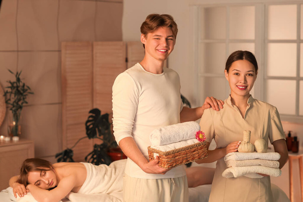 Hieronta terapeutit pyyhkeet ja asiakas pimeässä kylpylä salonki - Valokuva, kuva