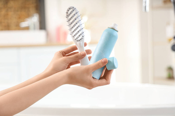 Giovane donna con shampoo a secco e spazzola in bagno, primo piano - Foto, immagini