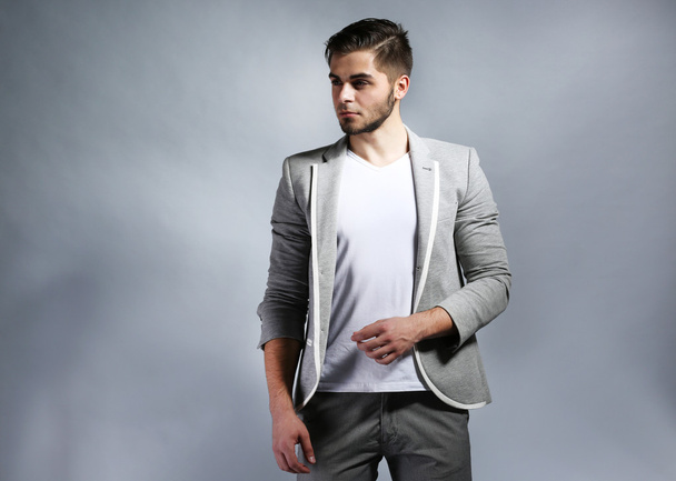 Young man on gray background - Фото, изображение