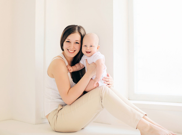 Happy mother and baby at home in light room - Foto, Bild