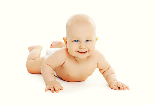 Portrait of cute baby in diapers lying on the floor - 写真・画像