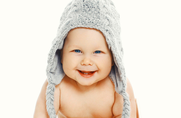 Smiling baby in knitted hat sitting on a white background - Φωτογραφία, εικόνα
