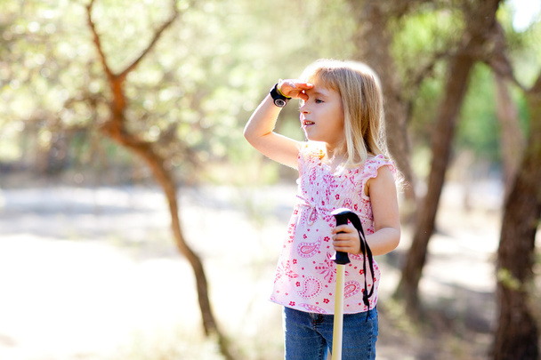 Hiking kid girl searching hand in head in forest - 写真・画像