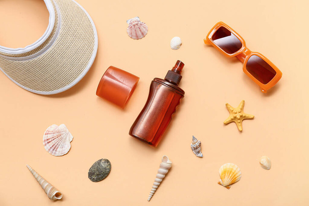 Strand accessoires met fles zonnebrandcrème op oranje achtergrond - Foto, afbeelding