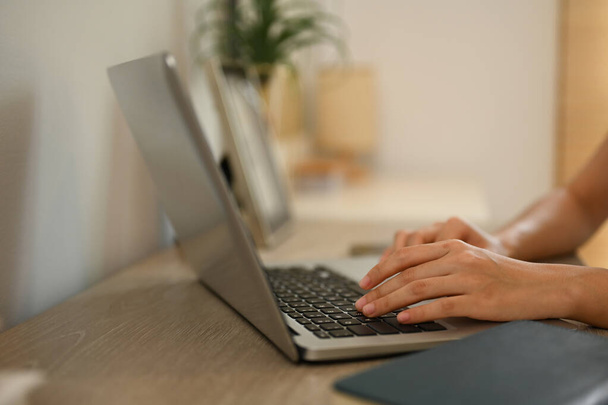 Blisko ujęcia kobiet ręce wpisując na klawiaturze laptopa pracy zdalnie z domu. - Zdjęcie, obraz