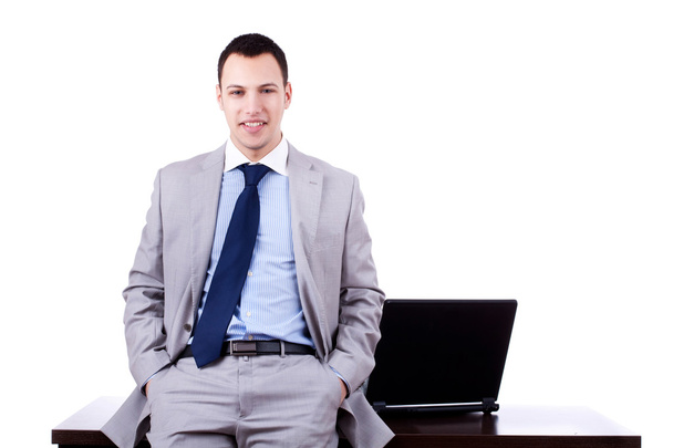 Businessman sitting against desk - Photo, Image