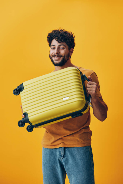 Διακοπές άνθρωπος τουριστική μπλε τσάντα τρόπο ζωής αναζητούν βαλίτσα τουρισμό πρόσωπο ταξίδι ένα νεαρό όμορφο αποσκευές πορτρέτο αποσκευών ενηλίκων ταξιδιώτη κίτρινο casual στούντιο διακοπές - Φωτογραφία, εικόνα