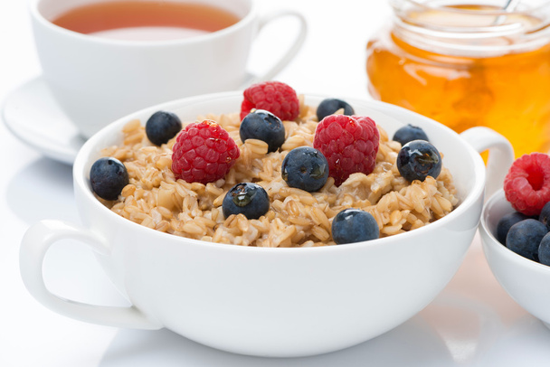 breakfast - oat porridge with fresh berries and honey, black tea - Fotoğraf, Görsel