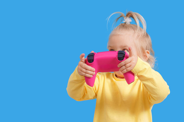 Joystick z konsoli do gier w rękach dziecka, radosne emocje u małej dziewczynki. - Zdjęcie, obraz