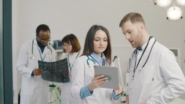 Groupe de médecins examinant l'information des patients sur comprimé - Séquence, vidéo