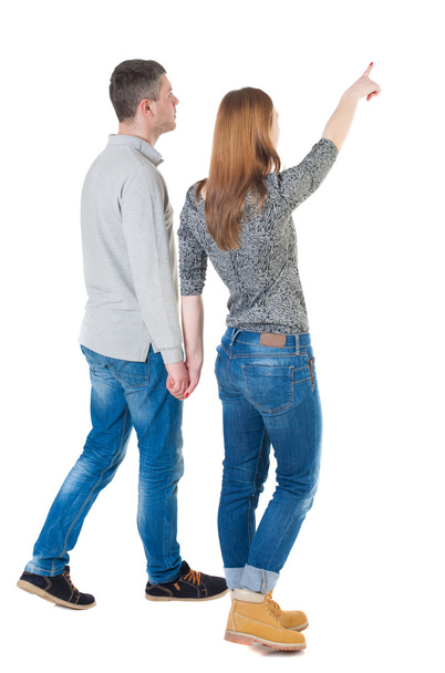 Back view of walking couple pointing - Фото, зображення