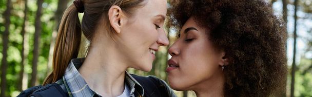 Nuori lesbo pari nauttii rauhallisesta vaelluksesta yhdessä, heidän kasvonsa valaistuvat rakkaudesta, jonka he jakavat. - Valokuva, kuva