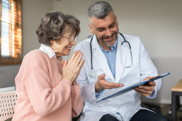 Догляд за чоловіком Лікар розмовляє і консультує задоволених літніх жінок-пацієнток, проводить регулярні оглядові консультації з клієнтом старшої жінки - Фото, зображення