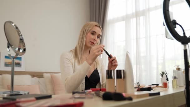 Young woman making beauty and cosmetic tutorial video content for social media. Beauty blogger smiles to camera while showing how to beauty care to audience or followers. Blithe - Footage, Video