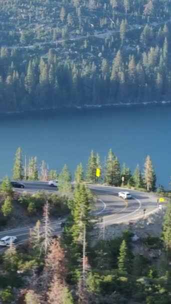 Schermo verticale: Cattura la bellezza del lago Tahoe, California in un video verticale con una strada tortuosa, vegetazione lussureggiante e acqua serena. Vivi la tranquillità della natura in questo filmato panoramico - Filmati, video