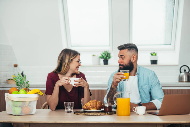 Szczęśliwa młoda para o romantyczny moment podczas śniadania w kuchni w domu podczas picia kawy - Zdjęcie, obraz