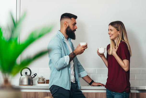 Młoda piękna zakochana para pije kawę w kuchni w domu - Zdjęcie, obraz