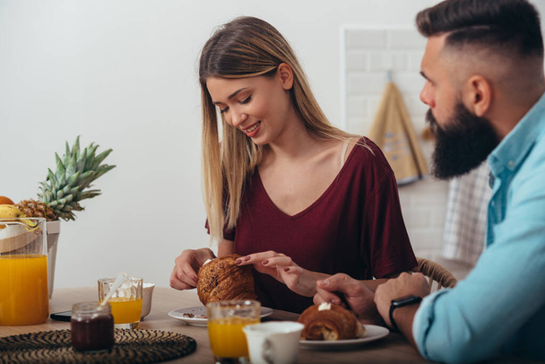 Aufnahme eines glücklichen jungen Paares beim gemeinsamen Frühstück zu Hause - Foto, Bild