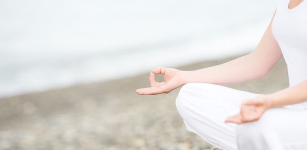 Main de femme méditant dans une pose de yoga sur la plage
 - Photo, image